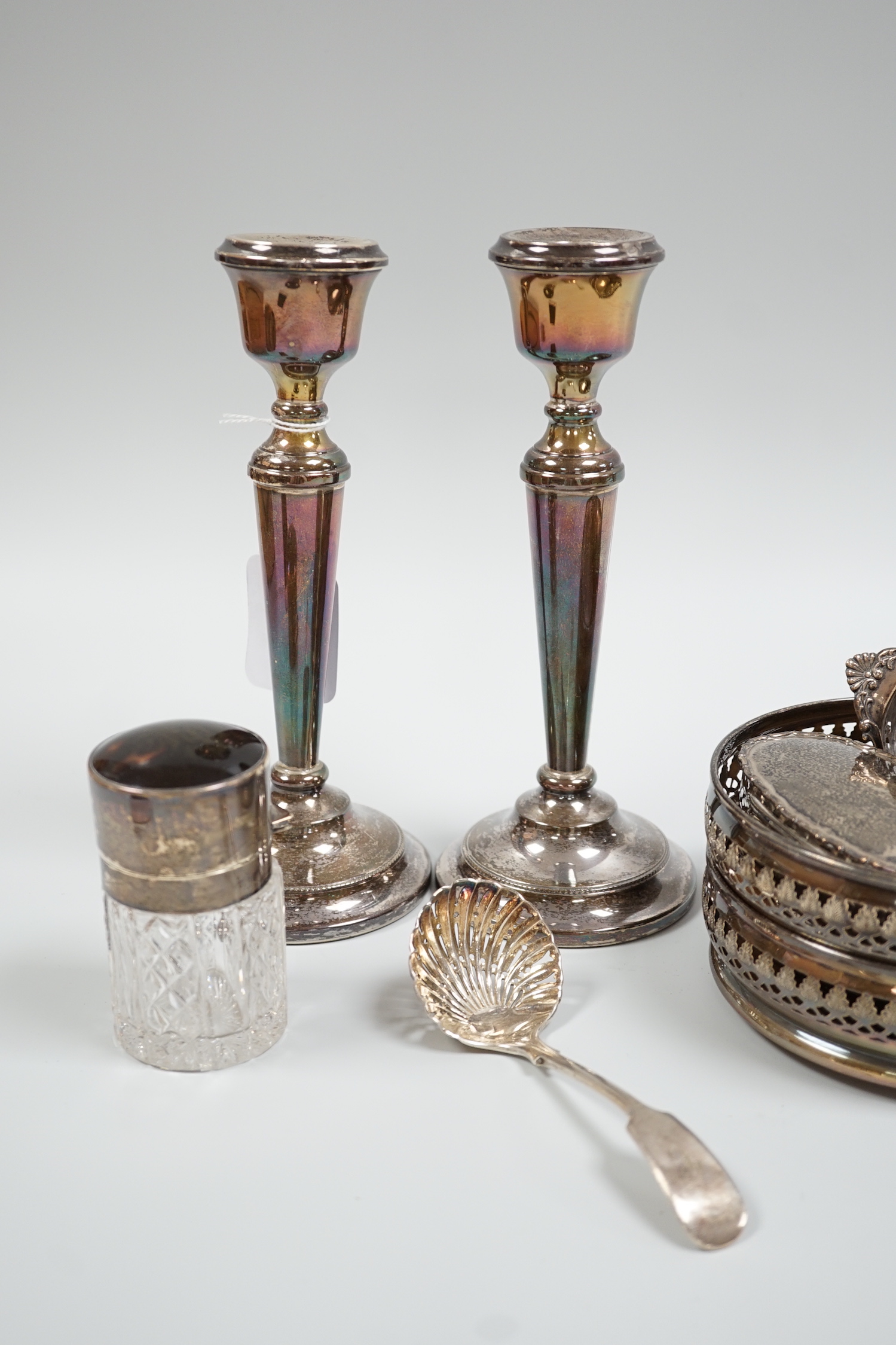 A pair of 1960's pierced silver wine coasters, London, 1968, diameter 13.2cm, a modern pair of silver candlesticks, a silver and tortoiseshell mounted glass salts bottle, a silver trinket box, sterling pierced dish, silv